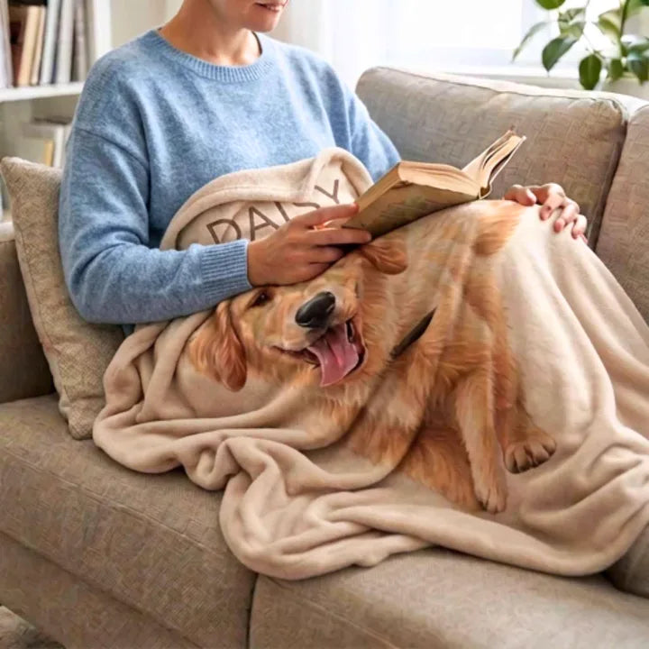 Someone reading on the sofa with a golden retriever painted on a custom pet photo blanket across their lap